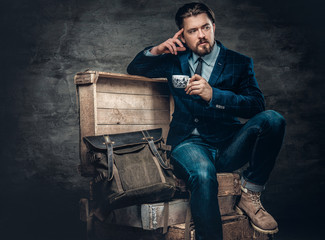 Casual man in a jeanssits on a box.