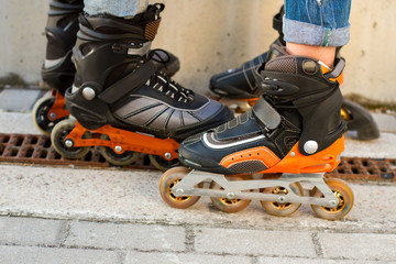 Legs in rollerblades. Inline skates and asphalt. Durable materials and new design.