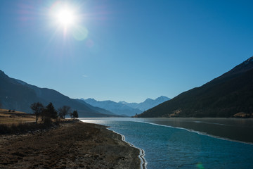 Fototapeta premium Sonniger Wintertag im Dezember am Reschensee in Südtirol / Italien