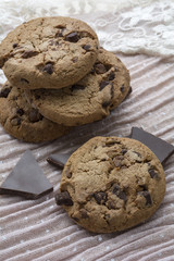 Sweet biscuits with dark chocolate are on the light pink background