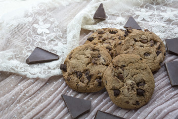 Four tasty biscuits with dark chocolate on the light pink background
