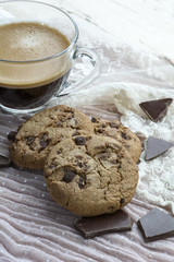 Glass cup of espresso with two cookies with dark chocolate on the pink background