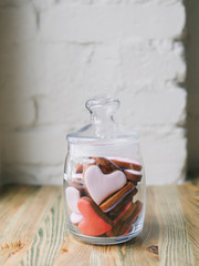 glass jar with cookies in the shape of heart