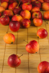 Naklejka na ściany i meble Fresh mini red apples on the straw background