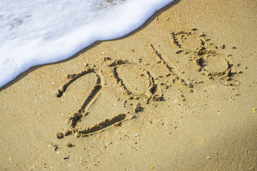 Abstract 2018 on a beach sand background
