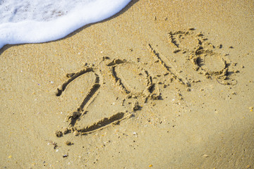 Abstract 2018 on a beach sand background