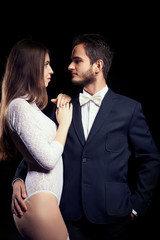 Hot woman in sexy body lingerie next to man in suit