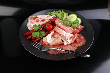 Food tray with delicious salami, pieces of sliced ham, sausage,