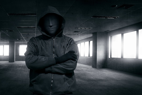 Hooded man with mask standing alone