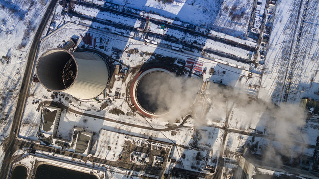 Heat electric station in winter. Aerial view. From above. Power station in a forest in sunny weather. Top view