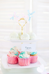Vanilla cupcakes with pink frosting and glittery butterflies, over dot background. Fun!