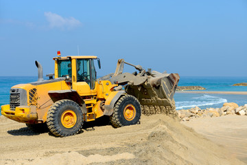 Fototapeta na wymiar bulldozer working on a beach