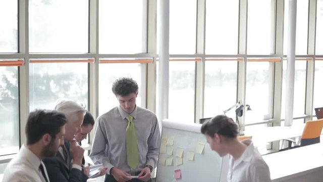 youngbusinessman making presentation of project to senior investior group of business people taking notes and make plans on white  flip board and tablet computer at startup office
