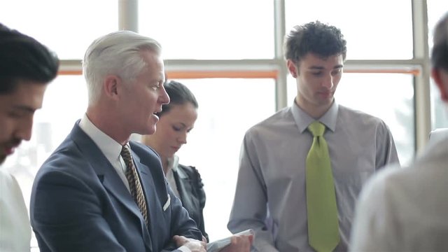 youngbusinessman making presentation of project to senior investior group of business people taking notes and make plans on white  flip board and tablet computer at startup office