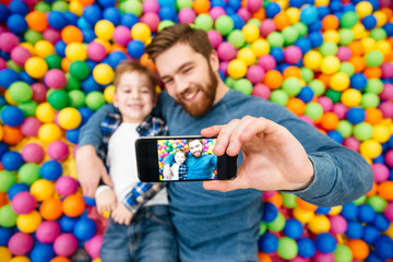 Boy and dad making selfie with mobile phone