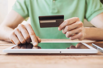 Hands holding credit card and using digital tablet. Online shopping concept