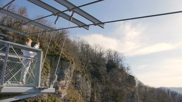 Woman take photos of the scenery nature views on the skybridge over the canyon