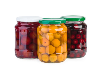 Glass jars with preserved cherries, plums and apricots