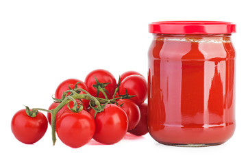 Glass jar with tomato paste and cherry tomatoes