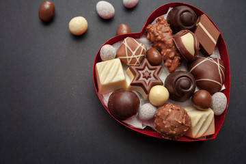 Chocolate pralines in red heart shape box