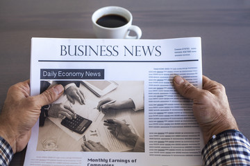 Man reading newspaper on table