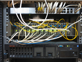 Server rack with internet patch cord cables connected to panel - obrazy, fototapety, plakaty