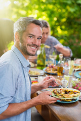 a man with gray hair lunching with friends on a terrace table