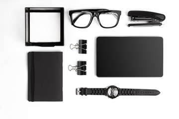 Blank notepad with clips, pens and glasses flat lay.