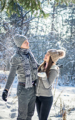 Couple shakes fir branch with snow