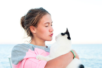 Portrait of young teenage girl kissing cat.