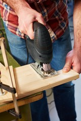 Closeup photo of man using jigsaw