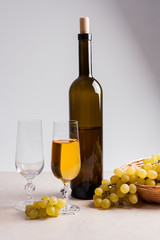 White wine and grapes. White wine in glass with bottle and grape