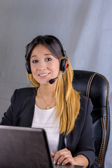 businesswoman talking on the phone while working on her computer at the office on white background