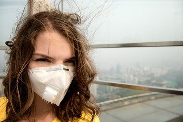 Woman in medical mask against the air pollution