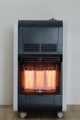 infrared heater is working at home on a brick wall background