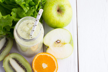 smoothies, lettuce, kiwi, avocado, apples and oranges - view from above