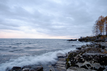 Beautiful waves on the lake, frozen fishermen in the background