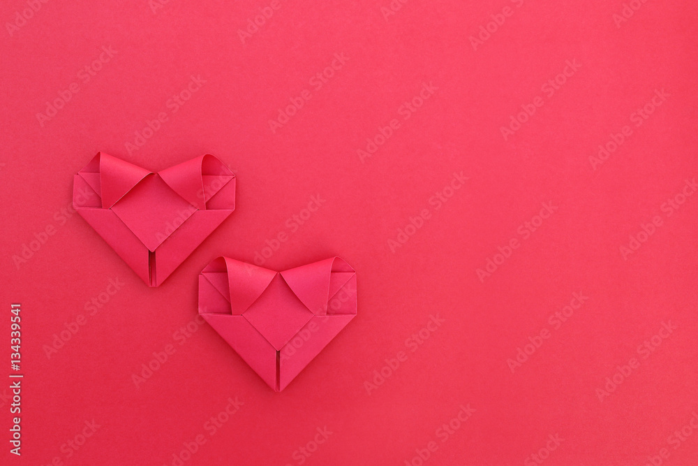 Poster two folding red paper hearts on red for pattern and background