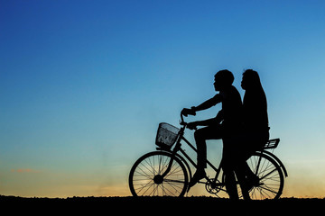 Obraz na płótnie Canvas young girl on a bicycle at sky.
