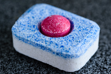 All-in-one dishwasher tablet with red ball in center.