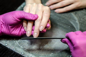 The process of creating forms of nail using nail files.
