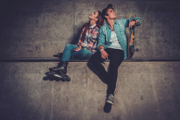 Cheerful couple with with skateboard outdoors