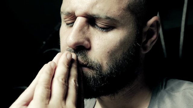Man with beard prays hard for the sick child