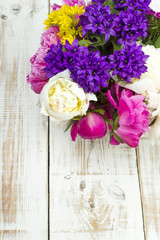 bouquet of colorful flowers on white wooden planks