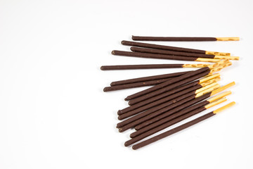 Fototapeta premium Biscuit cookie sticks in cacao coating on white background / Chocolate, cookies, biscuits coated bar.