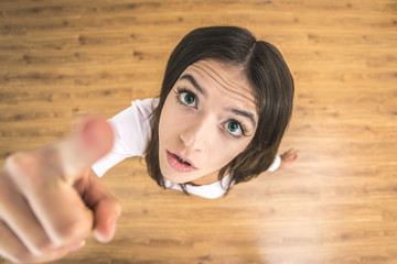 The woman show forefinger to the camera. View from above