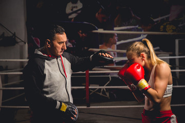 Women boxer hits mitts held by her trainer - obrazy, fototapety, plakaty