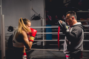 Women boxer hits mitts held by her trainer