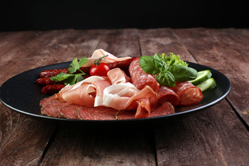 Food tray with delicious salami, pieces of sliced ham, sausage,