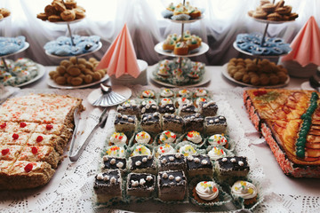 Tasty pieces of different cakes with chocolate and fruits stand